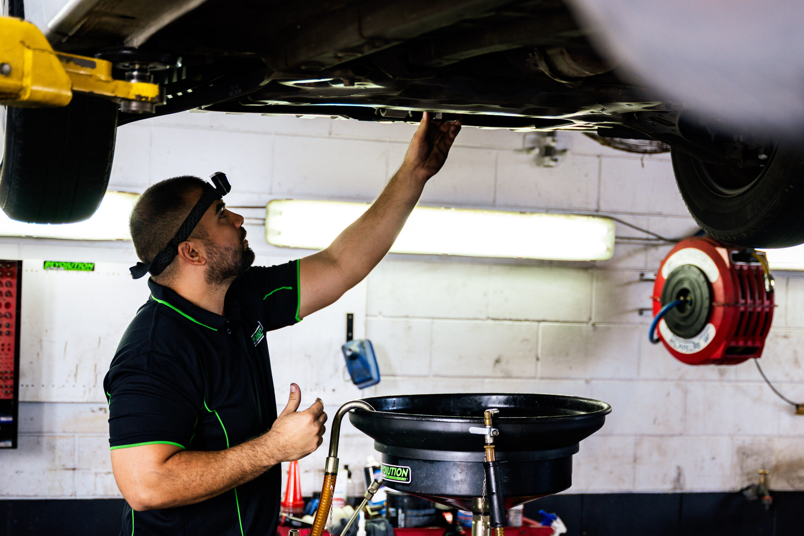 Mechanic performing oil change during a logbook service